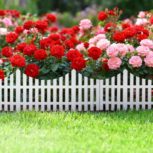 Balts plastmasas dārza žodziņš ap puķēm